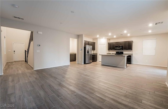 kitchen featuring stainless steel fridge, visible vents, open floor plan, and black microwave