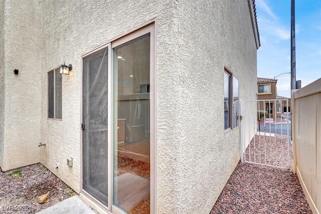 view of property exterior featuring stucco siding and fence