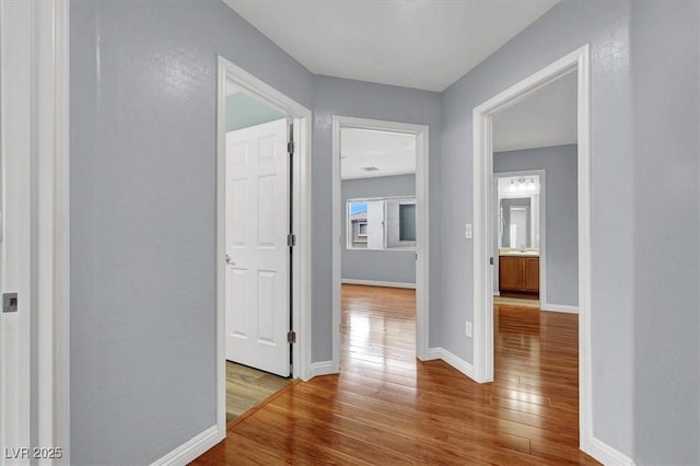 hallway with baseboards and wood-type flooring