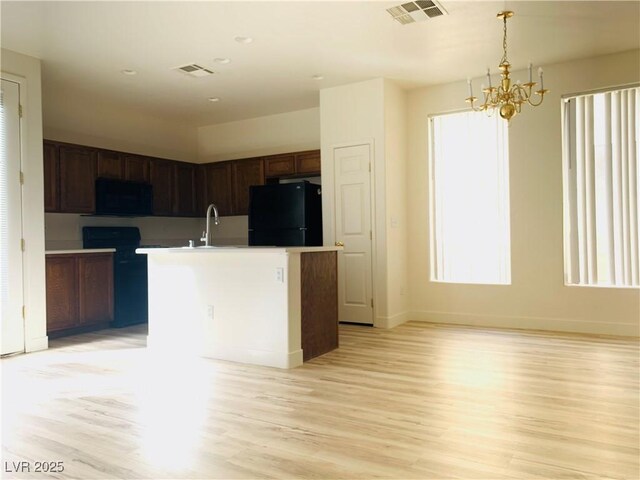 kitchen featuring black appliances, light wood-style flooring, visible vents, and a sink