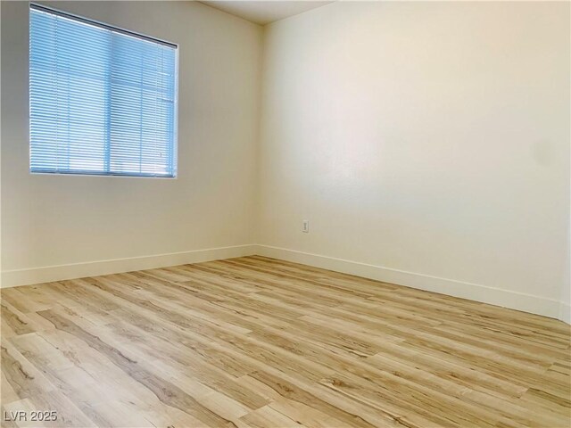 unfurnished room featuring light wood-type flooring and baseboards