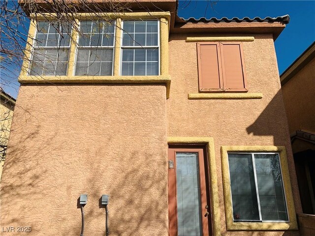 exterior space featuring stucco siding and a tile roof