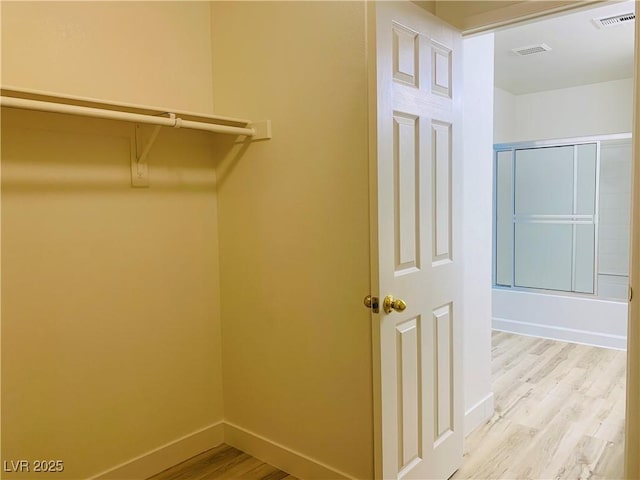 walk in closet with light wood-type flooring and visible vents