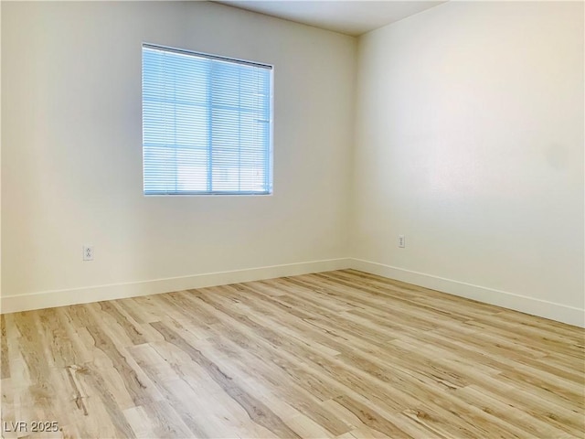 spare room with wood finished floors and baseboards