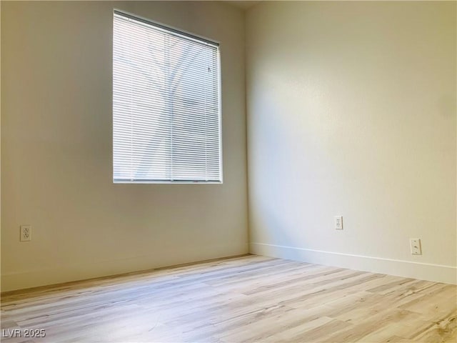 empty room with baseboards and wood finished floors