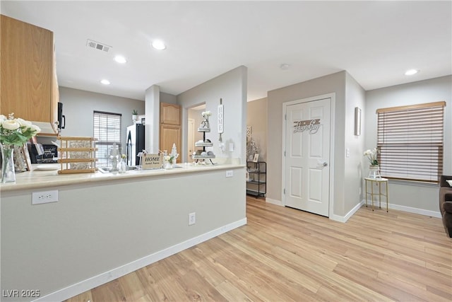 kitchen featuring light wood-type flooring, visible vents, recessed lighting, and freestanding refrigerator