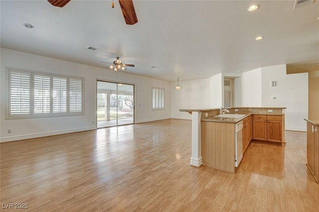 kitchen with visible vents, a sink, light wood-style floors, dishwasher, and open floor plan