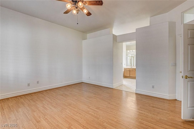 unfurnished room with a ceiling fan, light wood-style floors, and baseboards