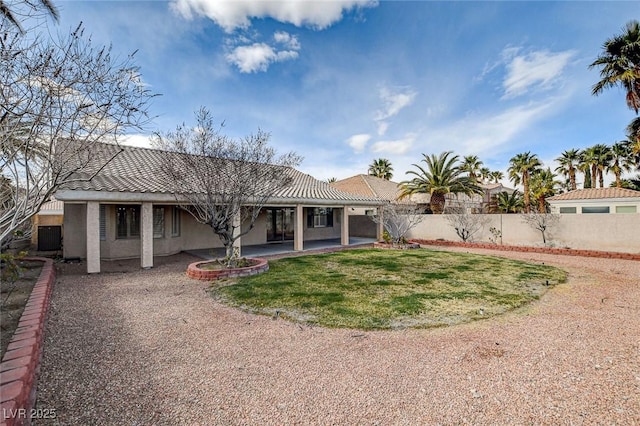 back of house featuring a patio area, stucco siding, a lawn, and fence