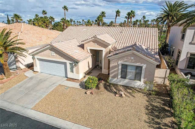 view of front facade featuring a tile roof, a garage, driveway, and stucco siding