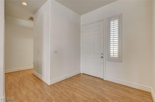 foyer featuring visible vents, baseboards, and light wood-style floors