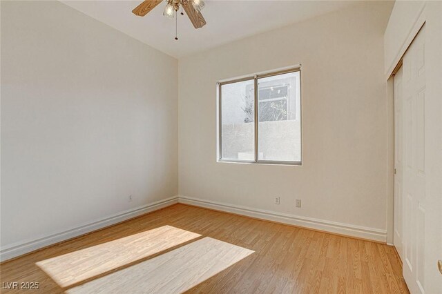 unfurnished bedroom featuring a closet, light wood-style flooring, baseboards, and ceiling fan