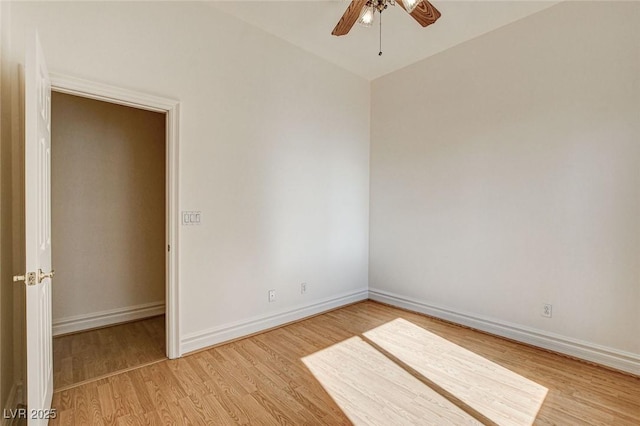 unfurnished room featuring baseboards, light wood-style floors, and ceiling fan