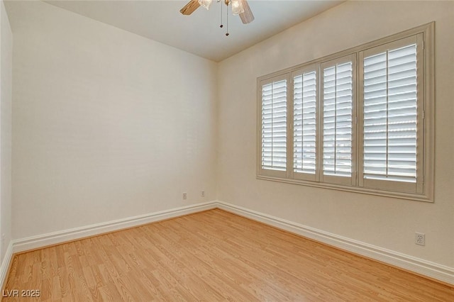 spare room featuring baseboards, wood finished floors, and a ceiling fan