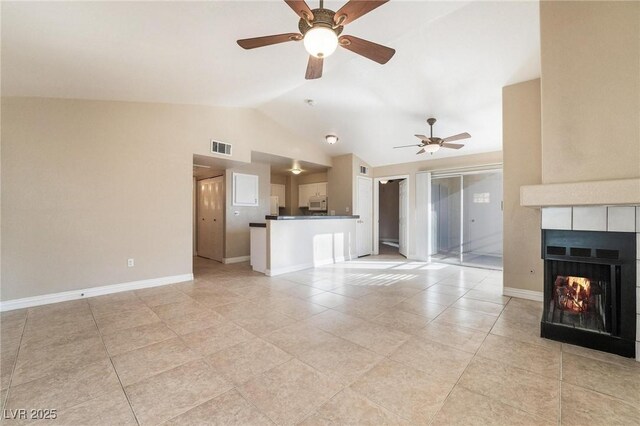 unfurnished living room with visible vents, lofted ceiling, baseboards, and a fireplace