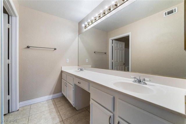 bathroom featuring a sink, visible vents, double vanity, and tile patterned flooring