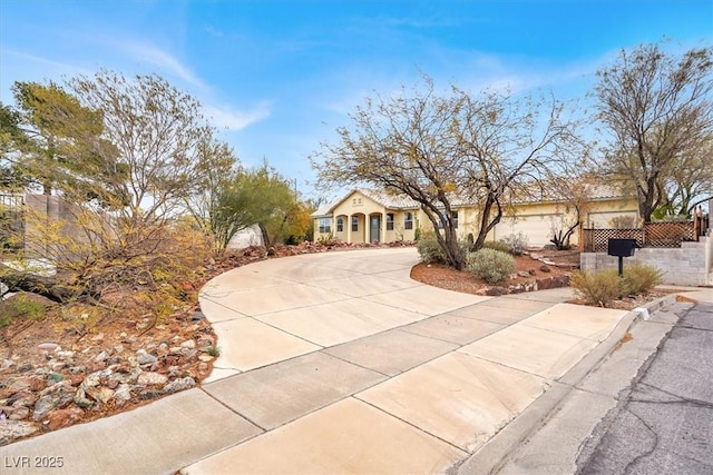 view of front of property with concrete driveway and fence