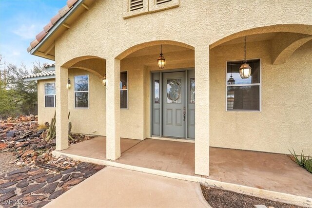 entrance to property featuring stucco siding and a tiled roof