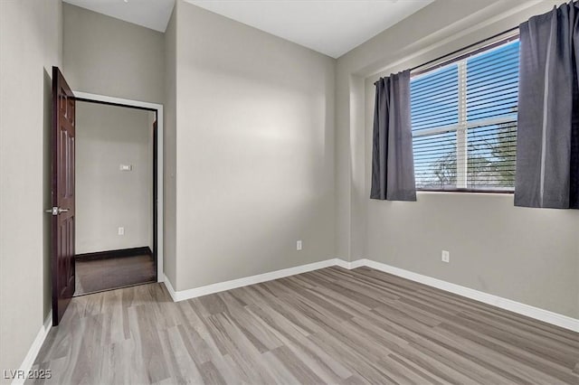 unfurnished room with baseboards and wood finished floors