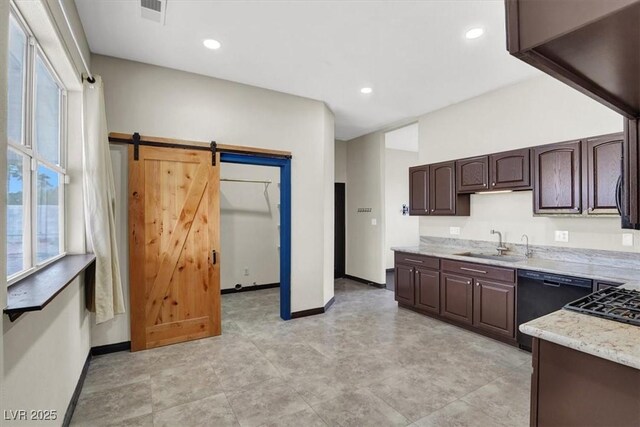 kitchen with baseboards, dark brown cabinetry, a barn door, black dishwasher, and a sink