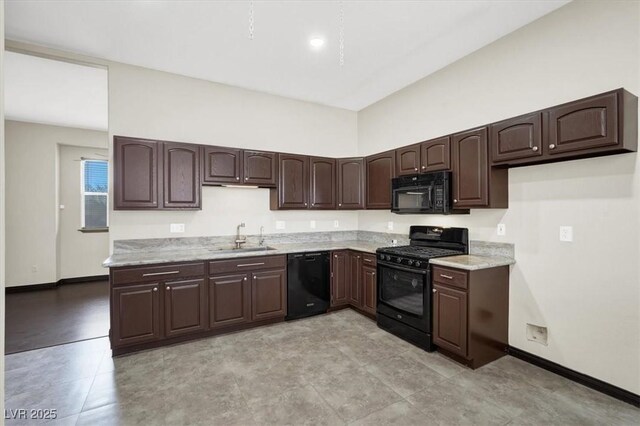 kitchen featuring dark brown cabinets, black appliances, baseboards, and a sink