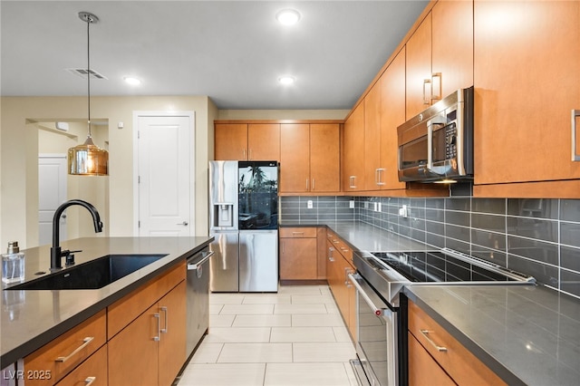 kitchen with dark countertops, visible vents, decorative backsplash, stainless steel appliances, and a sink