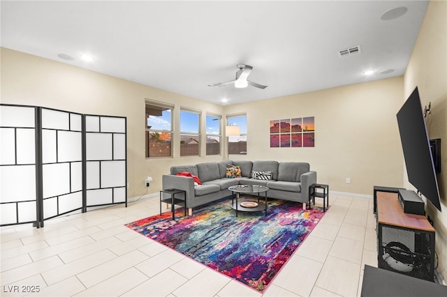 living area with visible vents, baseboards, ceiling fan, and tile patterned flooring