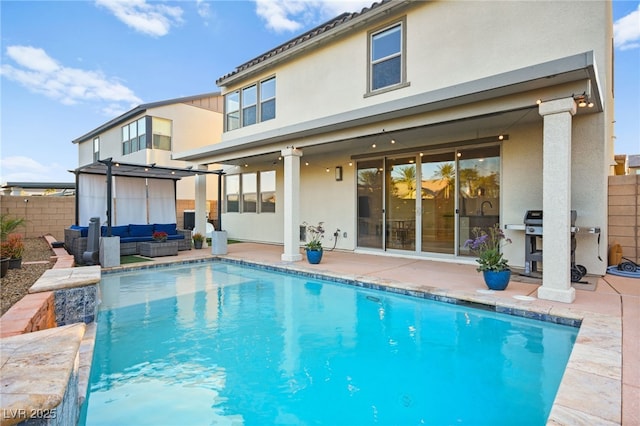 rear view of house featuring a fenced in pool, fence, stucco siding, outdoor lounge area, and a patio area