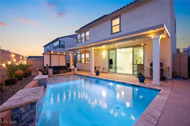 rear view of property featuring a fenced in pool, stucco siding, an outdoor hangout area, a fenced backyard, and a patio area