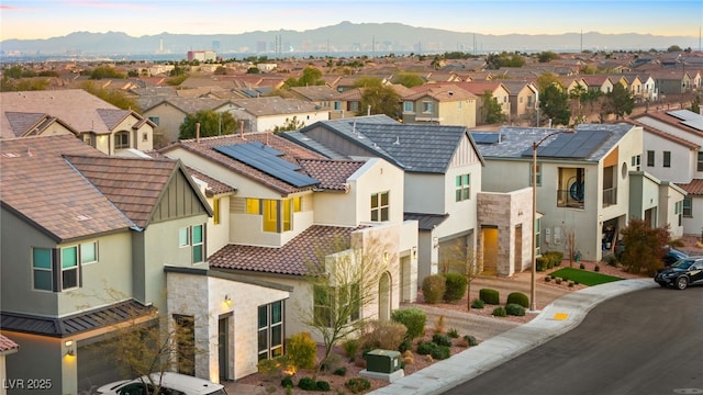 view of front of property featuring stucco siding, stone siding, a mountain view, a residential view, and a tiled roof