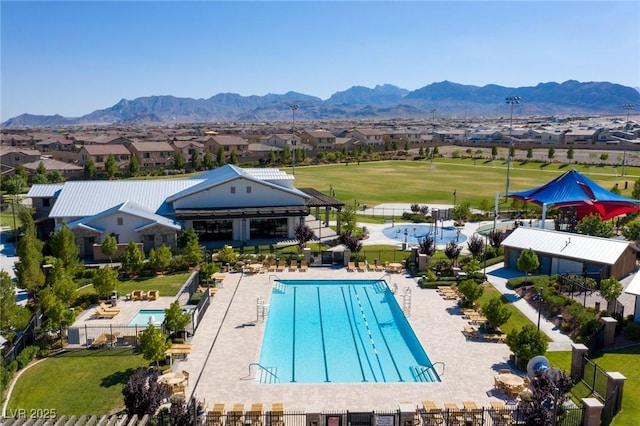 pool with a residential view, a mountain view, and fence