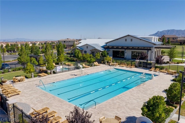 pool featuring a patio area, a mountain view, and fence