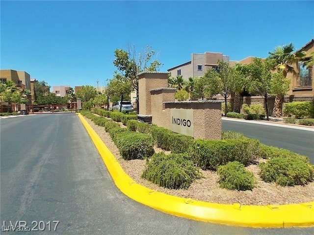 view of road with curbs, a residential view, and a gated entry