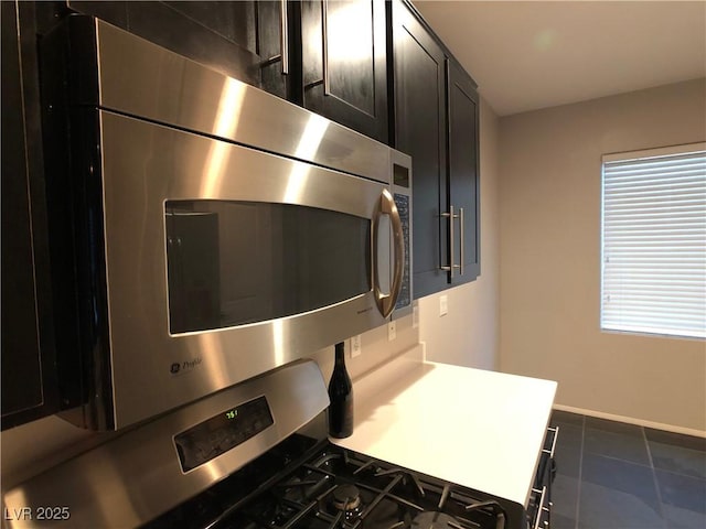 interior details with oven, stainless steel microwave, and baseboards