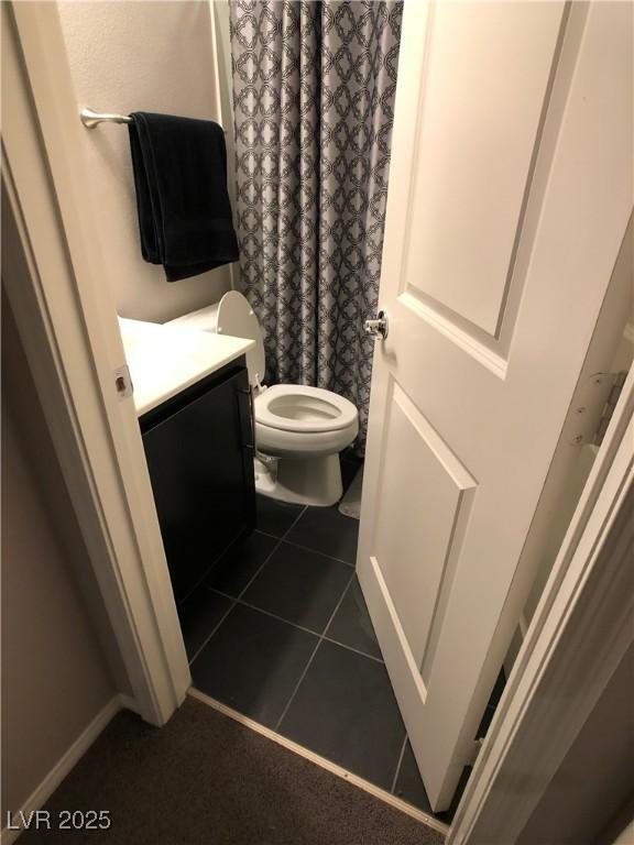 bathroom featuring tile patterned floors, toilet, a shower with shower curtain, and vanity