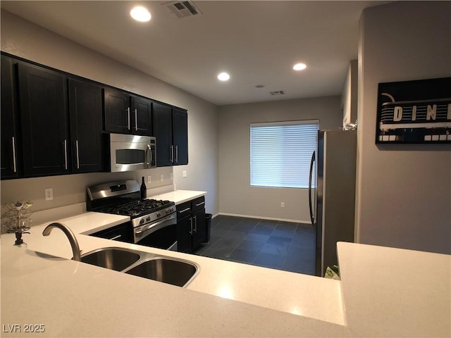 kitchen featuring visible vents, appliances with stainless steel finishes, dark cabinets, and light countertops