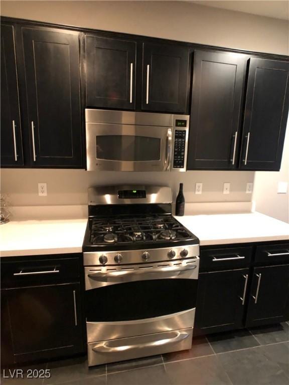 kitchen featuring light countertops, dark cabinets, and stainless steel appliances