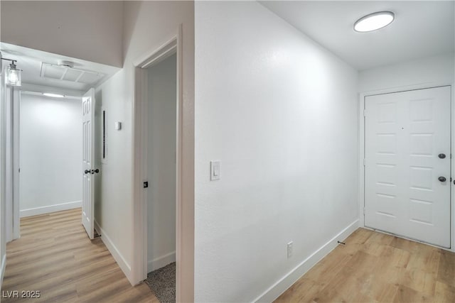 hall featuring baseboards and light wood-style flooring