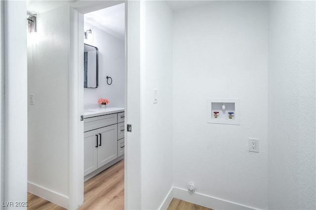 laundry room with washer hookup, laundry area, light wood-style flooring, and baseboards