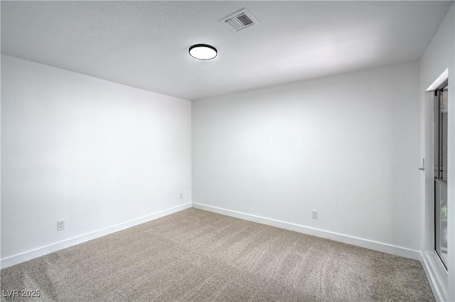 empty room featuring carpet flooring, baseboards, and visible vents