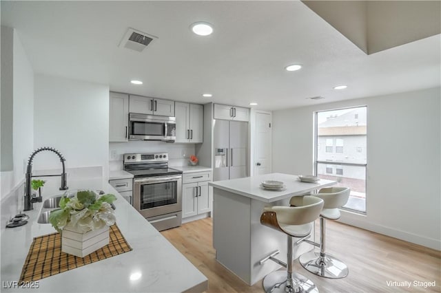 kitchen with light countertops, visible vents, appliances with stainless steel finishes, and light wood-type flooring