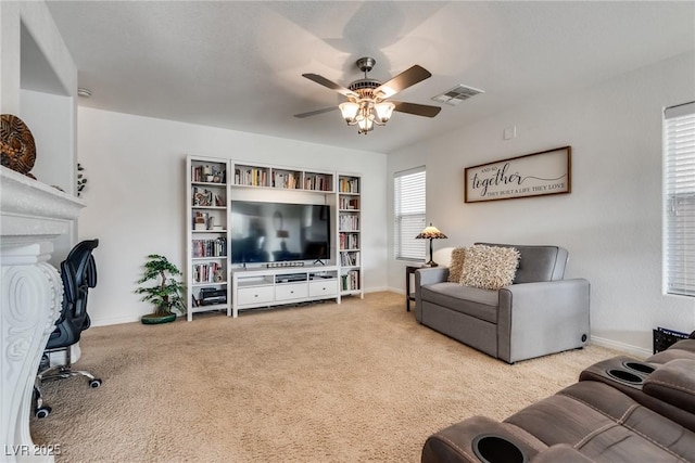 carpeted living room with a fireplace, a ceiling fan, visible vents, and baseboards