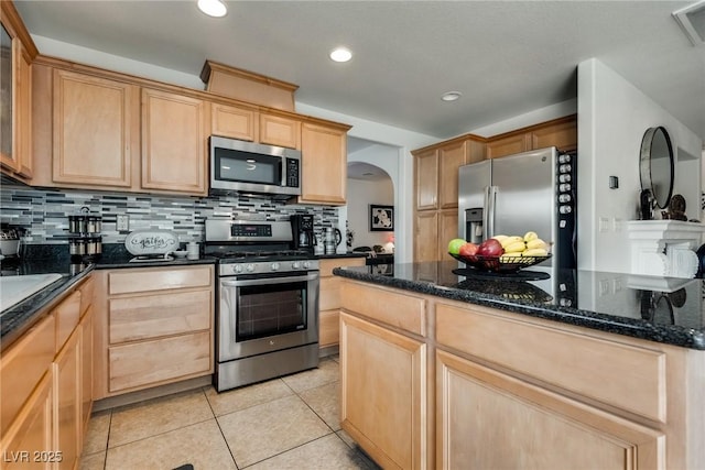 kitchen featuring tasteful backsplash, light brown cabinetry, and stainless steel appliances