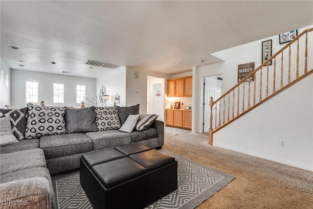 living room featuring stairs, light colored carpet, visible vents, and baseboards