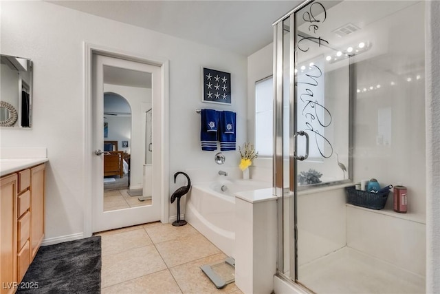 bathroom with vanity, a shower stall, ensuite bathroom, tile patterned floors, and a bath