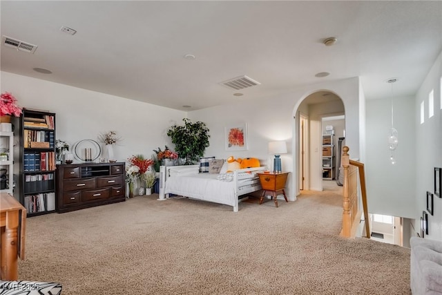 bedroom featuring arched walkways, visible vents, and carpet floors