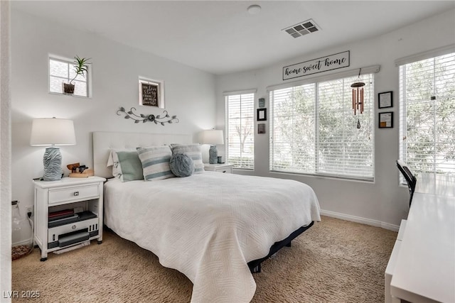 carpeted bedroom with multiple windows, baseboards, and visible vents