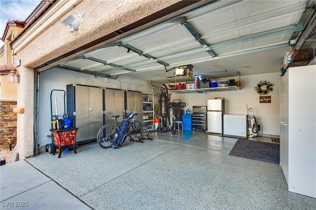 garage featuring fridge, gas water heater, a garage door opener, and freestanding refrigerator