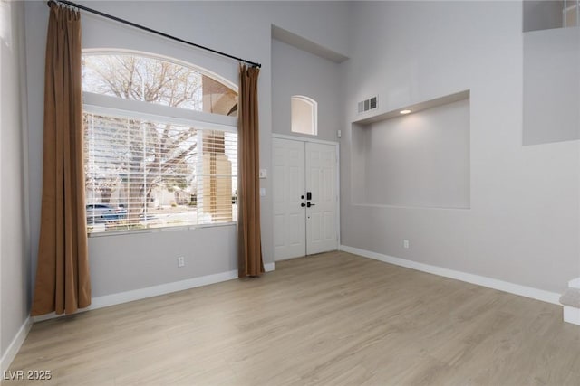 foyer with visible vents, baseboards, and light wood-style floors