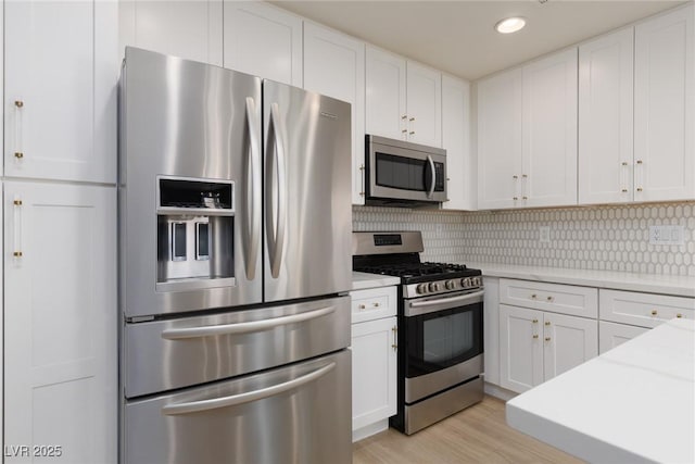 kitchen with white cabinets, tasteful backsplash, and appliances with stainless steel finishes